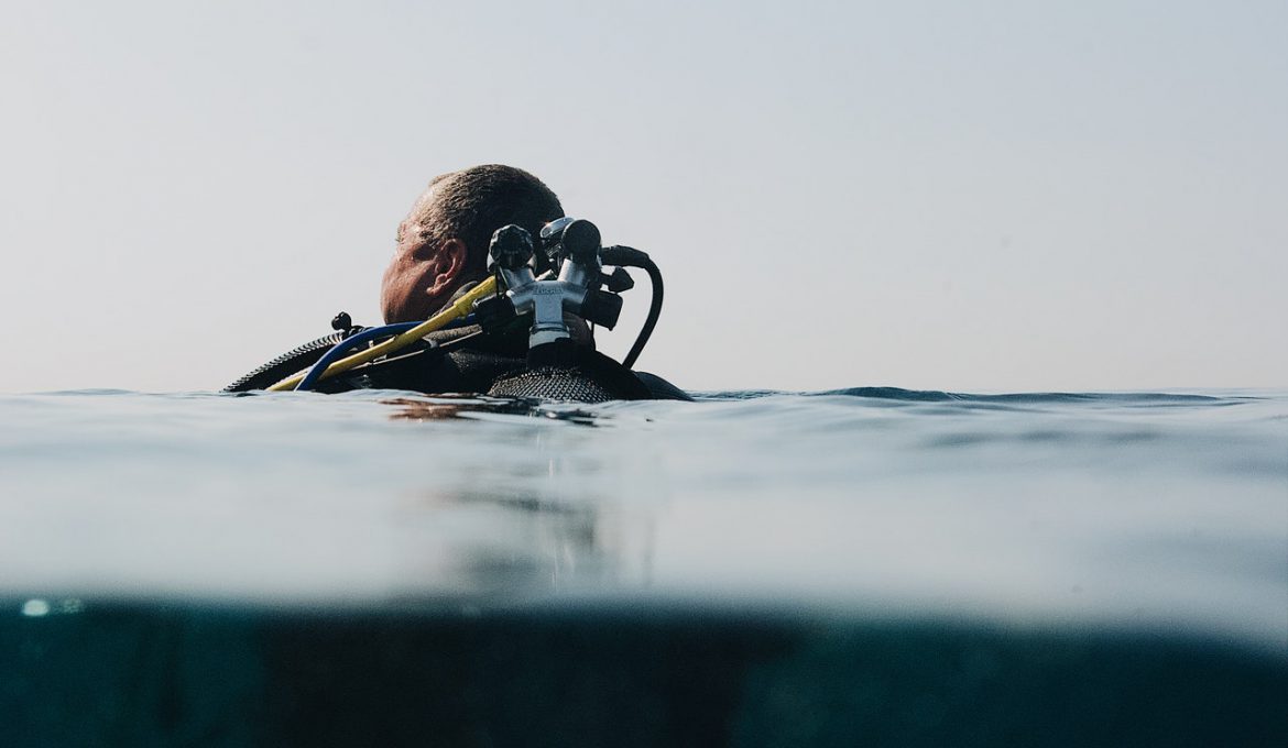 Mand er i dykkerudstyr ude i havet